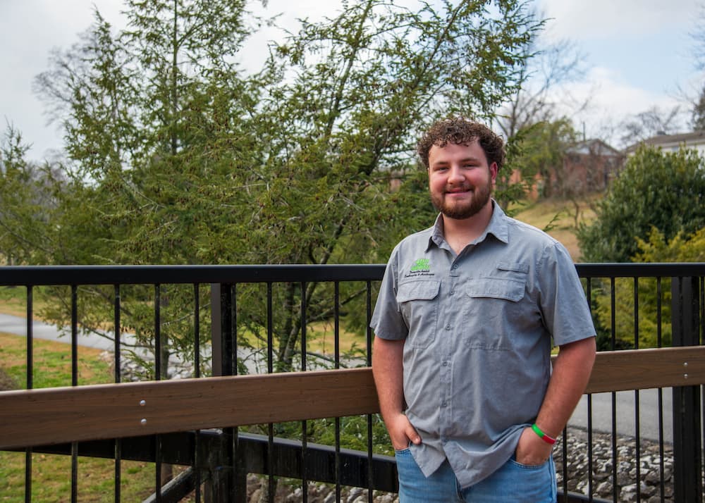 Brock, partner at HisGround LLC, standing outdoors on a bridge in Maryville, Tennessee.
