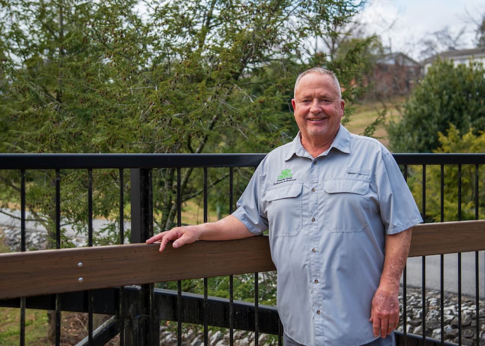 John, cofounder of HisGround LLC, standing outdoors on a bridge in Maryville, Tennessee.
